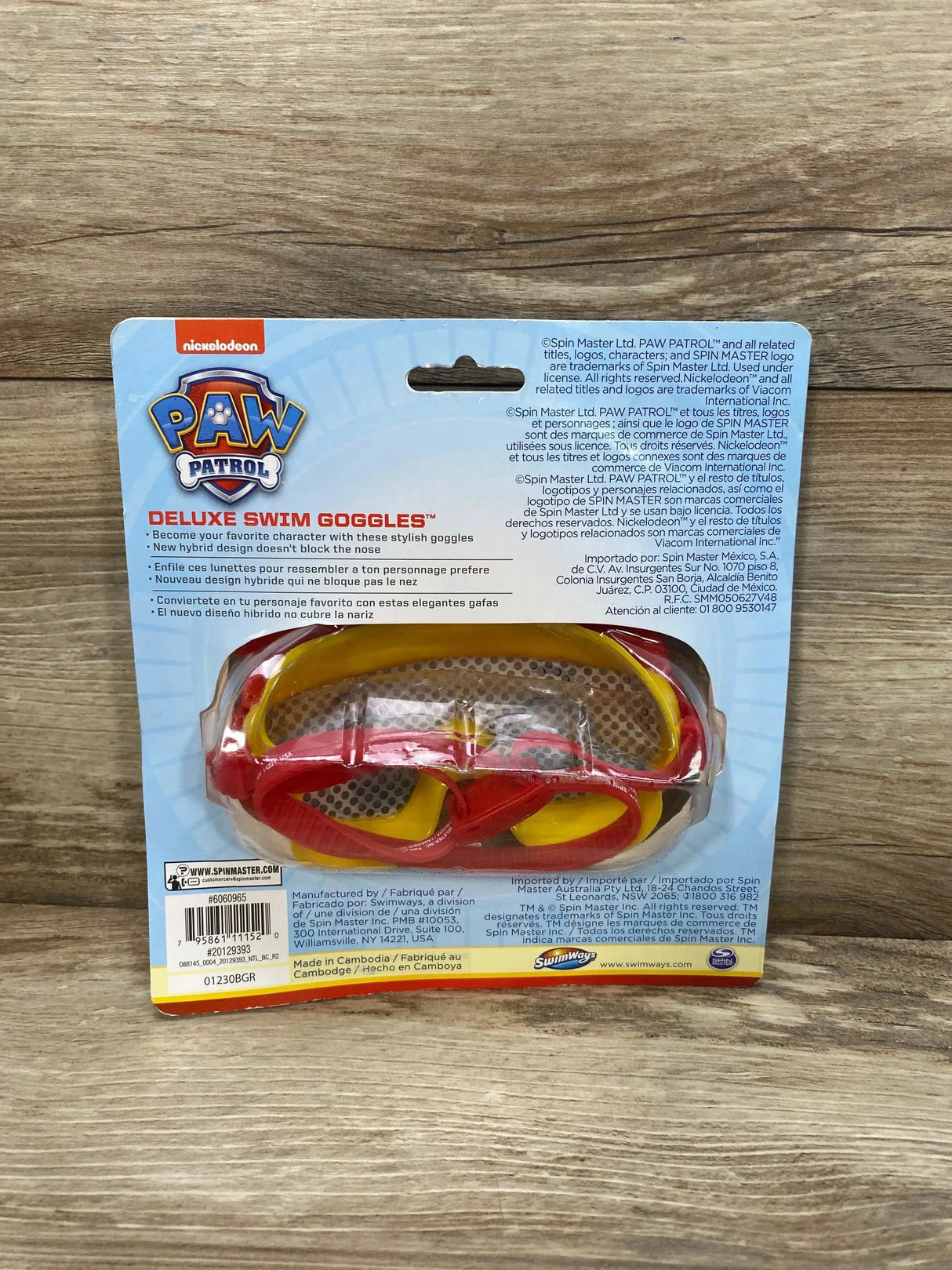 Front view of Paw Patrol Marshall swim goggles (red and yellow) in blister pack on wood surface