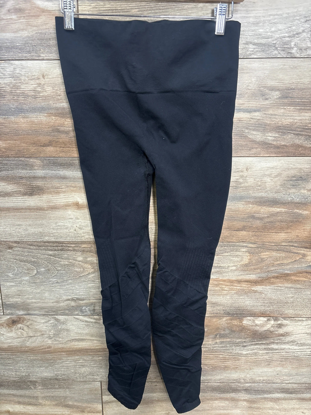 Front view of Blanqi maternity leggings showcasing high fold-over support waistband and textured knee panels with wooden background