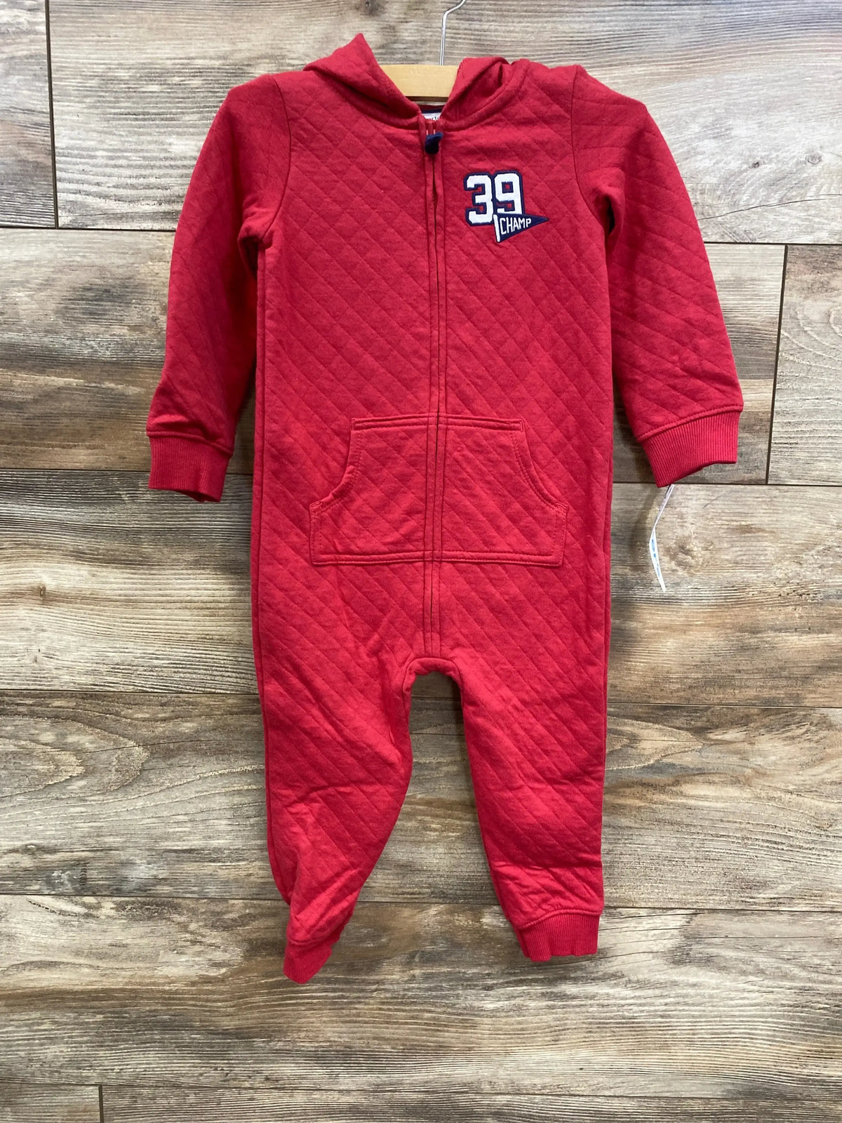 Red quilted baby jumpsuit with hood, front zipper, pockets, and 39 Champ patch
