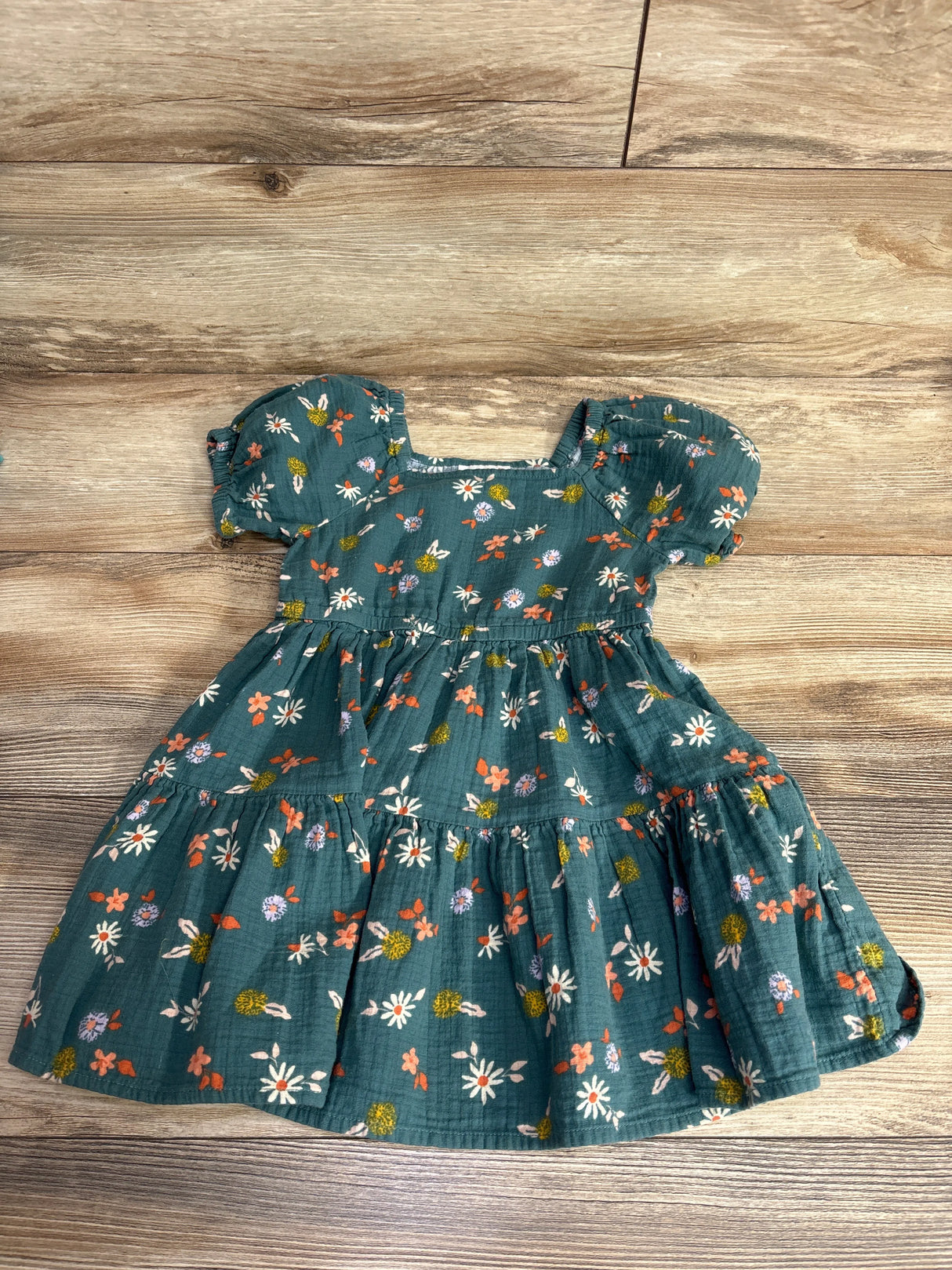 Green toddler dress with puff sleeves and floral print on wooden floor, kids clothing resale