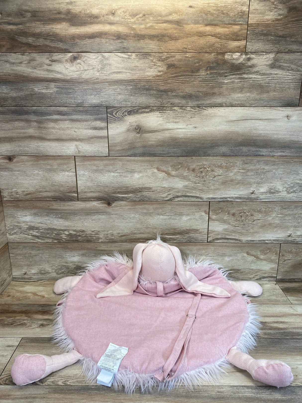Front view of RH Baby Wooly Plush Play Mat, Petal Bunny showing round pink mat with faux-fur trim and floppy ears