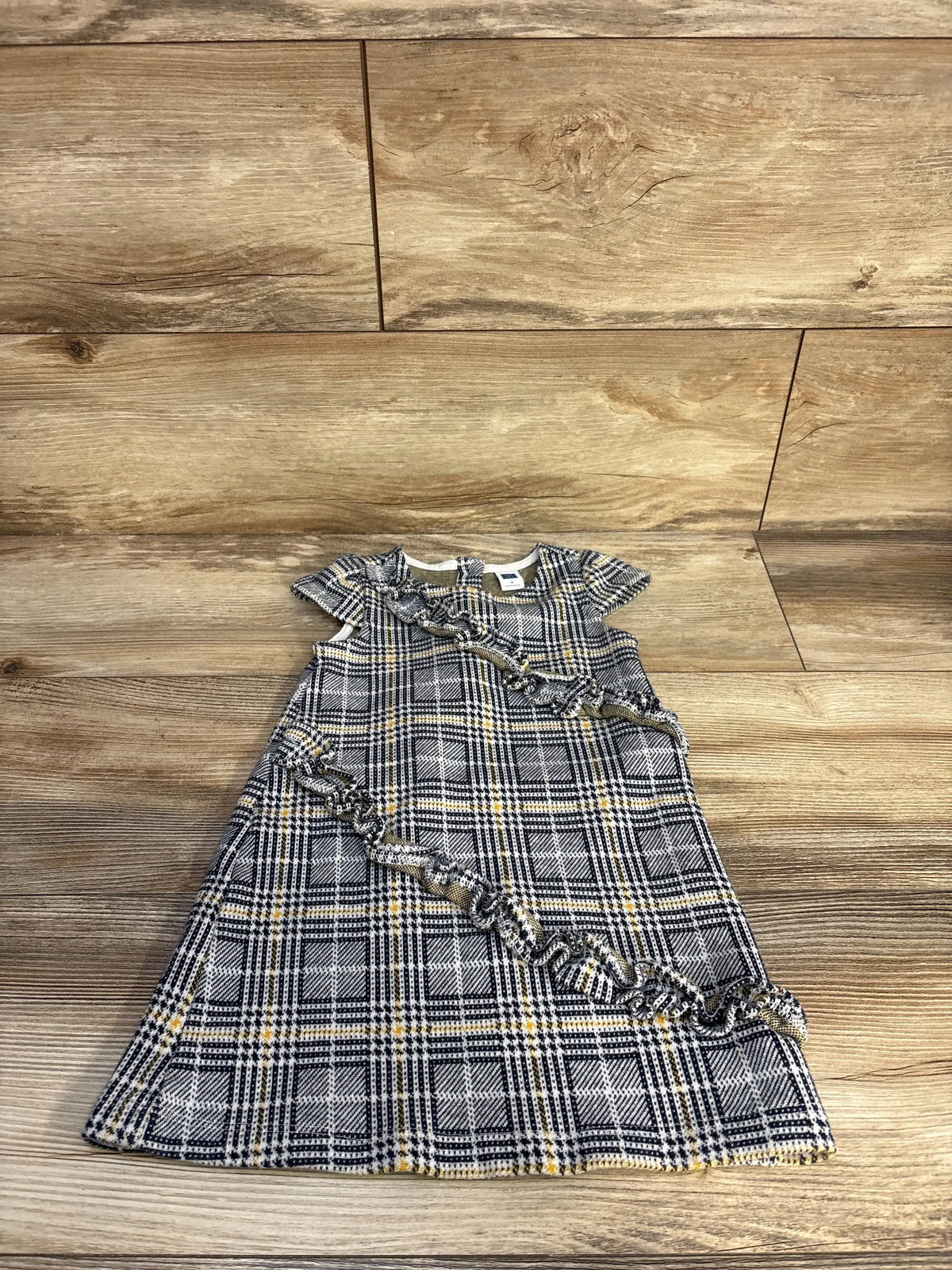 Front view of Janie & Jack navy plaid shift dress in size 3T with ruffle details and cap sleeves on a wood floor
