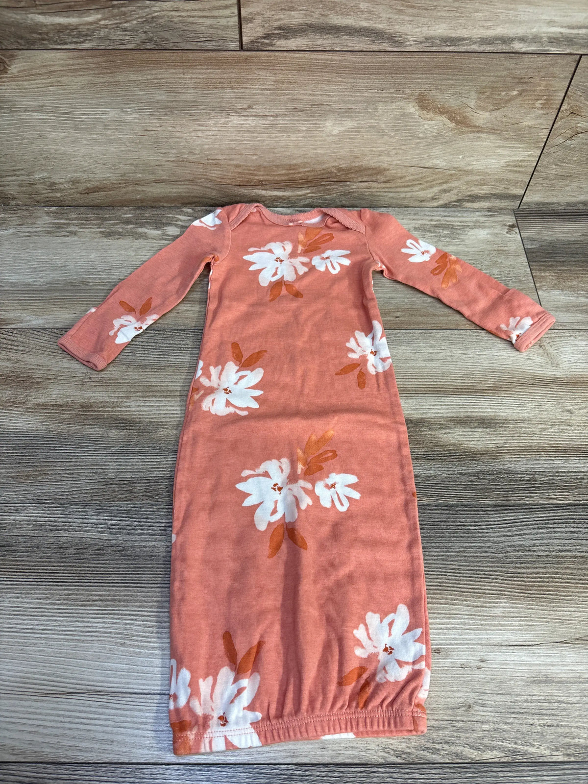 Front view of Carter’s coral sleep gown showcasing long sleeves and floral print on a wood-look background