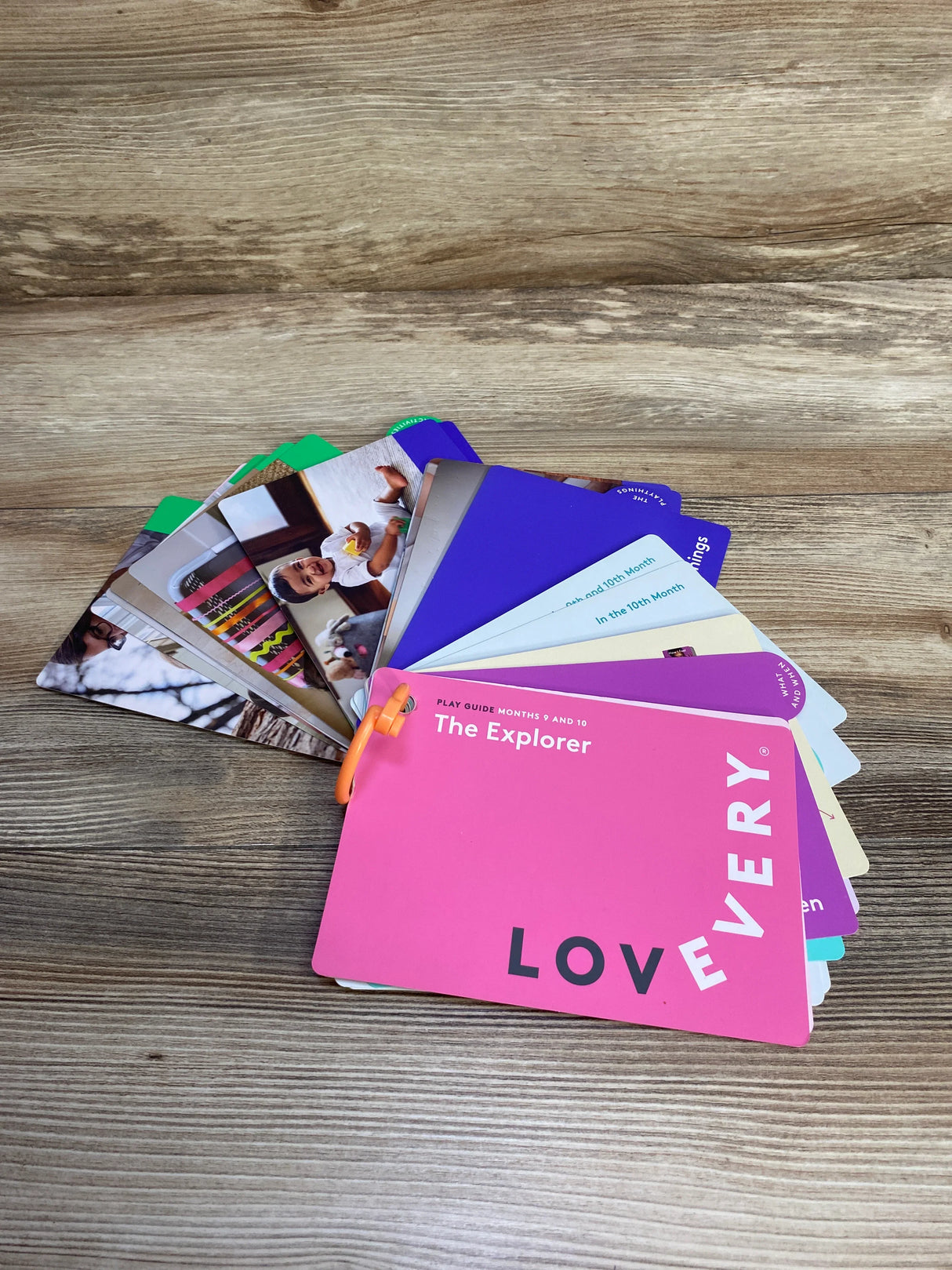 Lovevery Explorer play guide cards for months 9 and 10 on wood surface