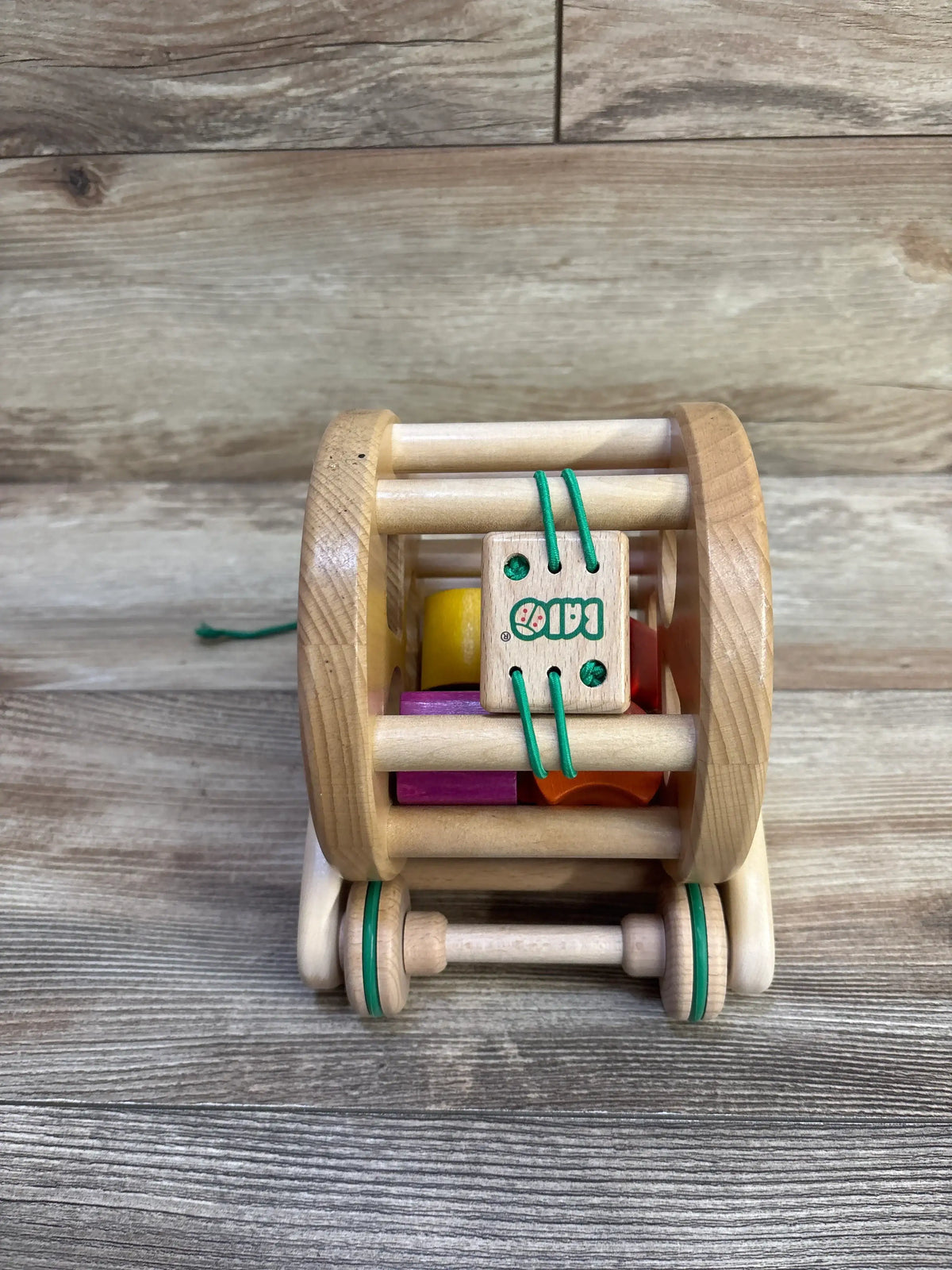 Front view of Bajo Wooden Snail Sortroller showcasing natural wood frame, green wheels, and colorful sorting pieces