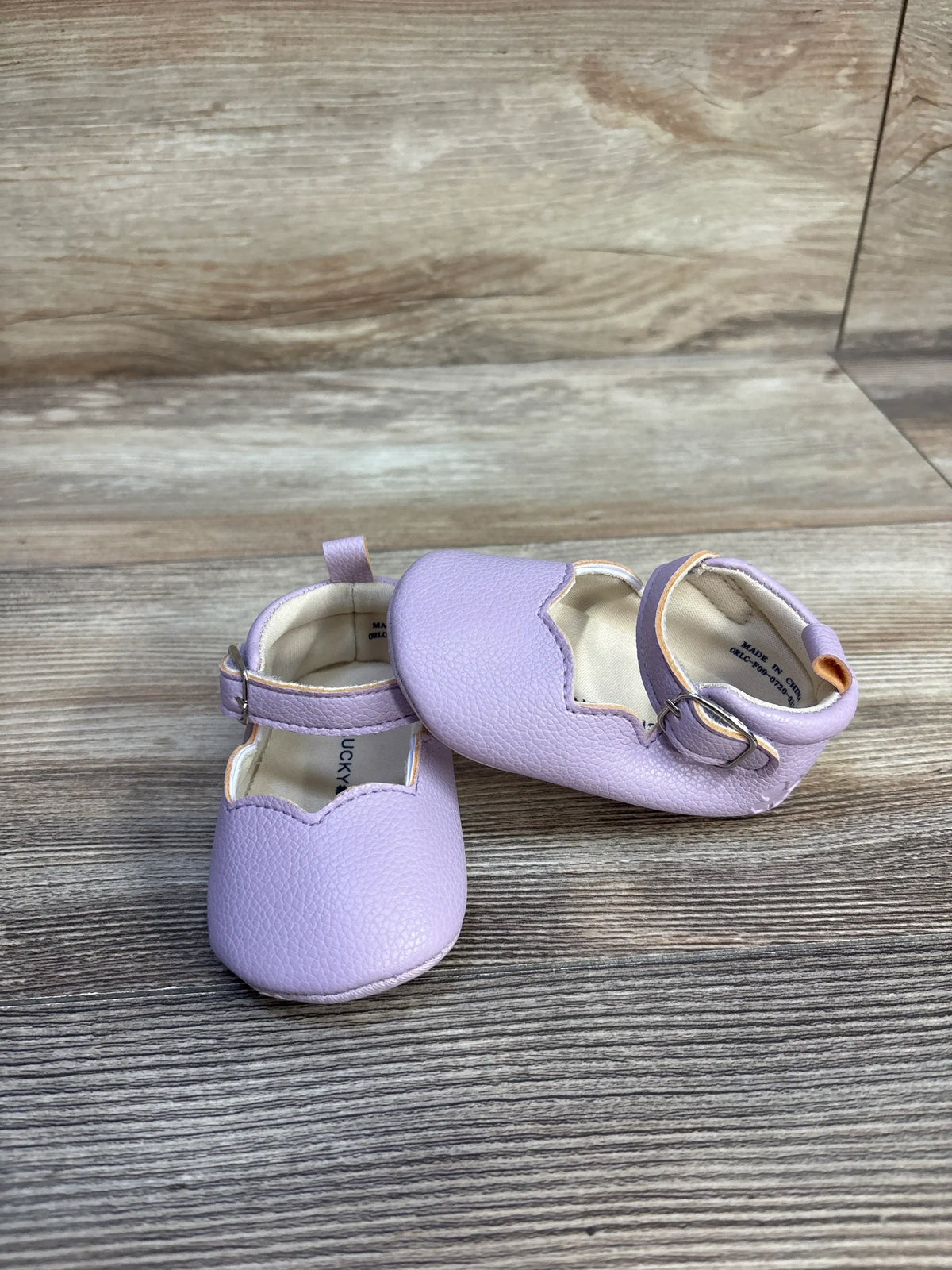 Front and side views of purple Lucky Brand Mary Jane crib shoes with hook and loop buckle closure and pull tabs