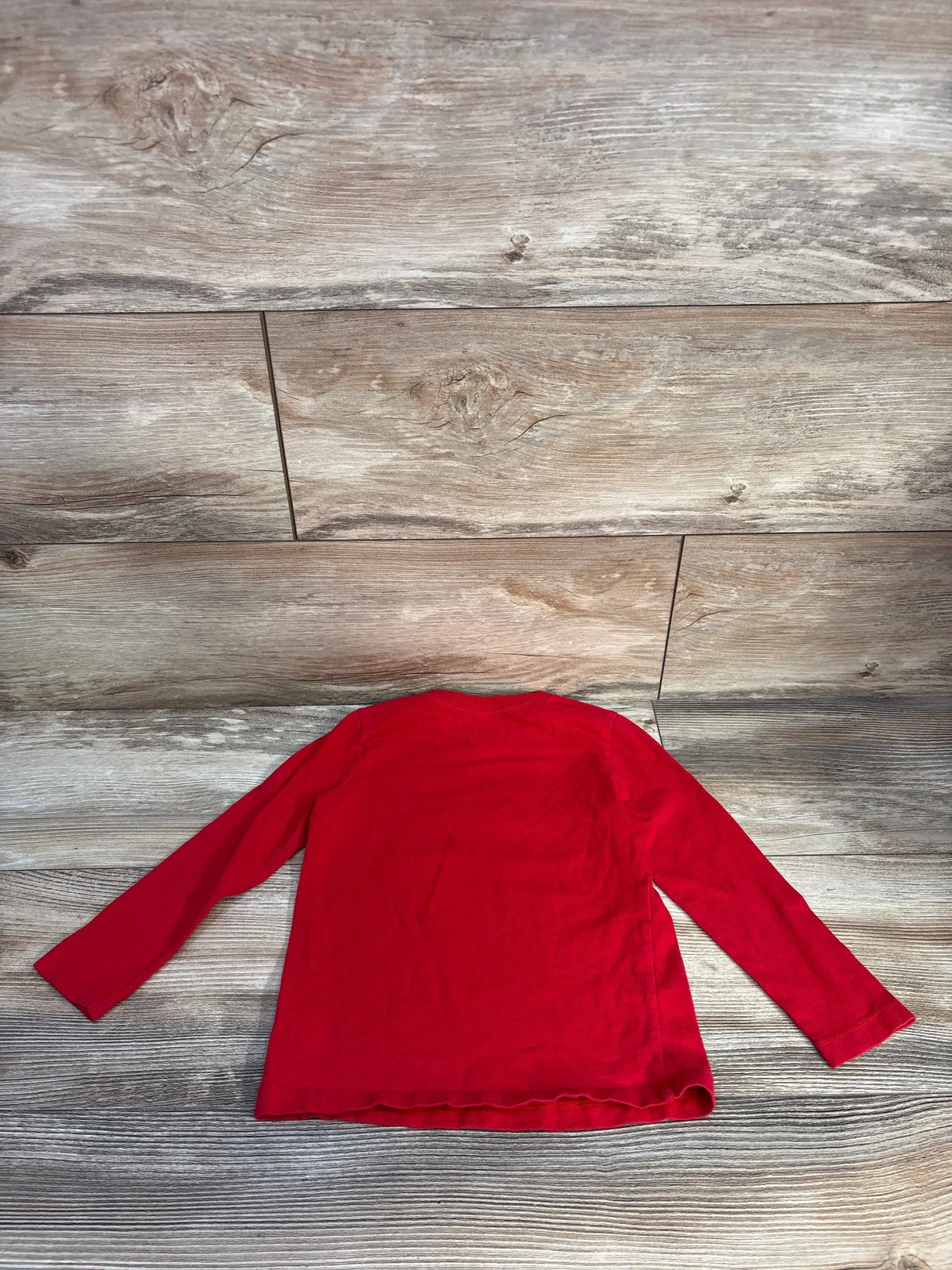 Back view of Carter’s Game On Shirt in red, showcasing long sleeves on a wood plank background