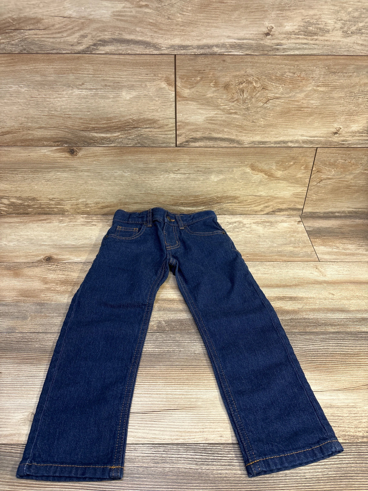 Front flat-lay of Cat & Jack toddler straight jeans in dark blue showing elastic waistband and straight legs on wood background