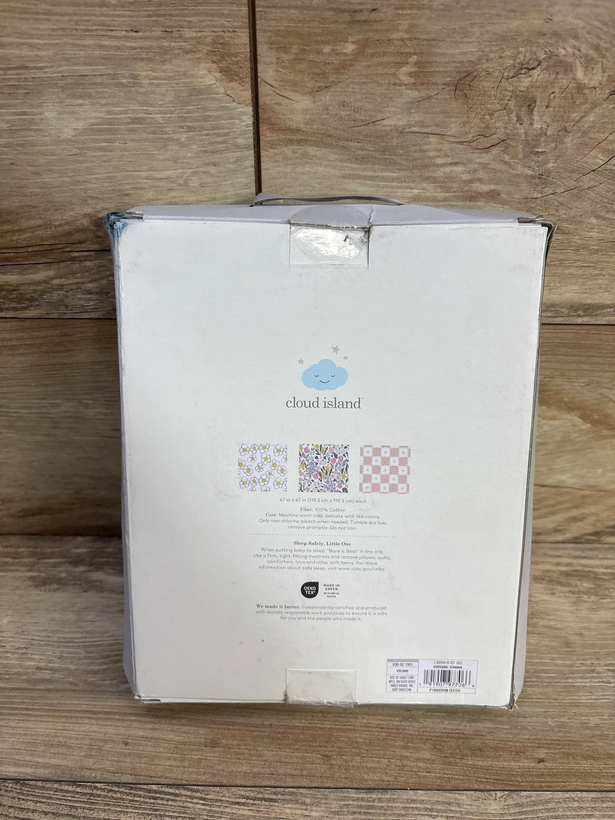 Front of Cloud Island 3-pack muslin swaddle box showcasing brand logo and three pattern thumbnails on wooden background