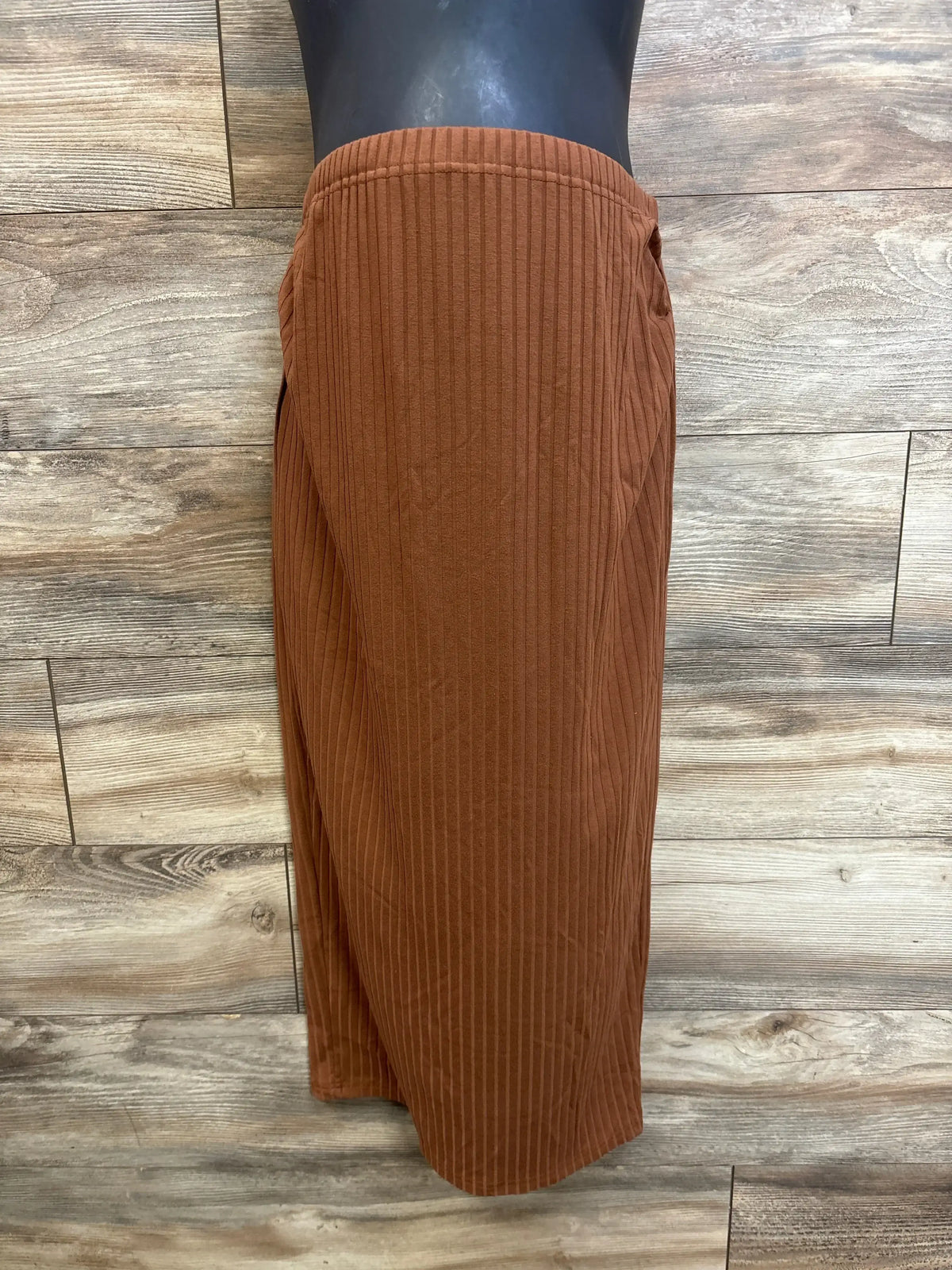 Front view of Ribbed Maternity Skirt in brown sz Large showcasing ribbed knit texture and long midi length on dress form with wood plank background