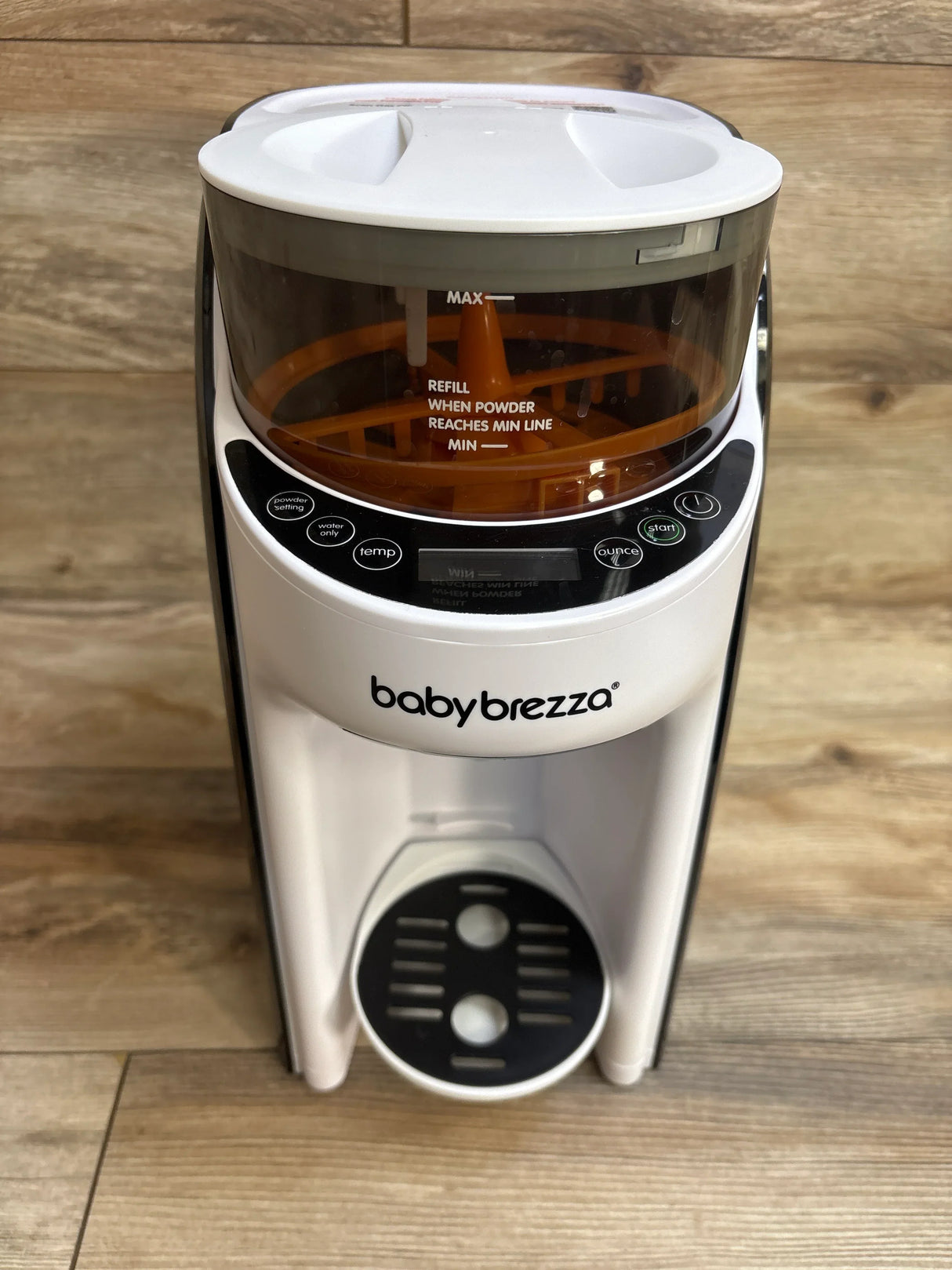 Baby Brezza formula dispenser and maker with white body on wooden floor