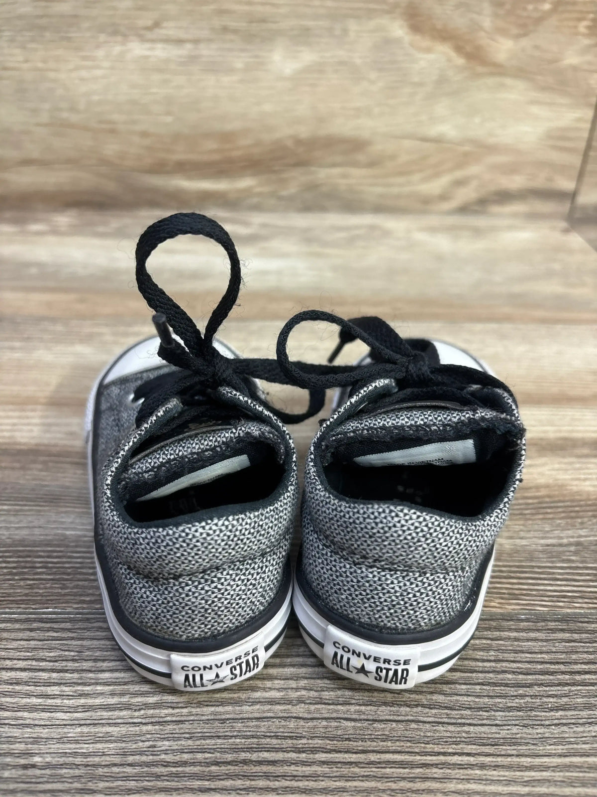 Rear view of Converse Madison Ox low-top sneakers in grey showing knit upper, black laces and All Star heel patch on wood background