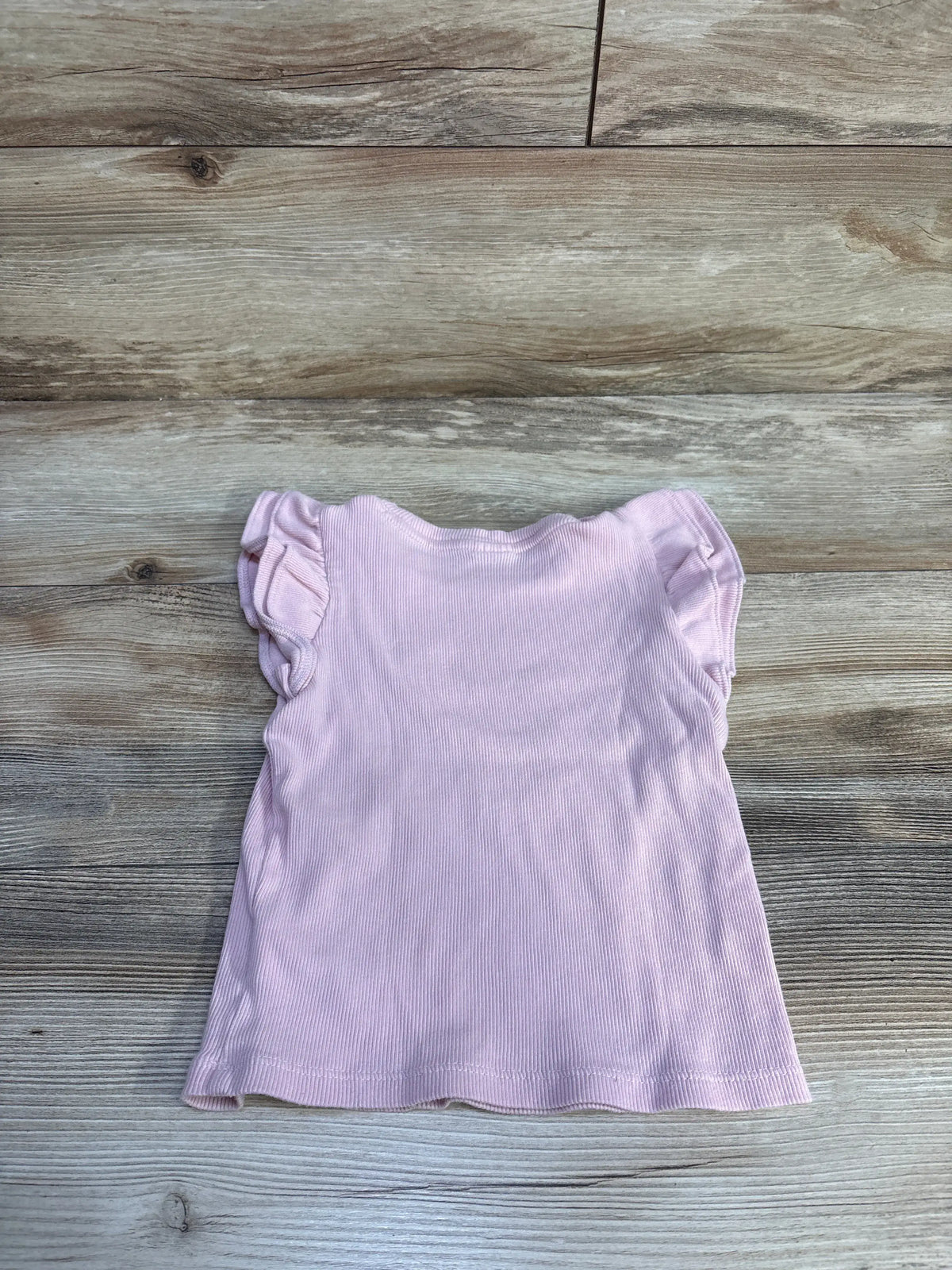 Flat lay of Baby Gap ribbed pink toddler shirt showcasing flutter sleeves and ribbed texture with wooden background