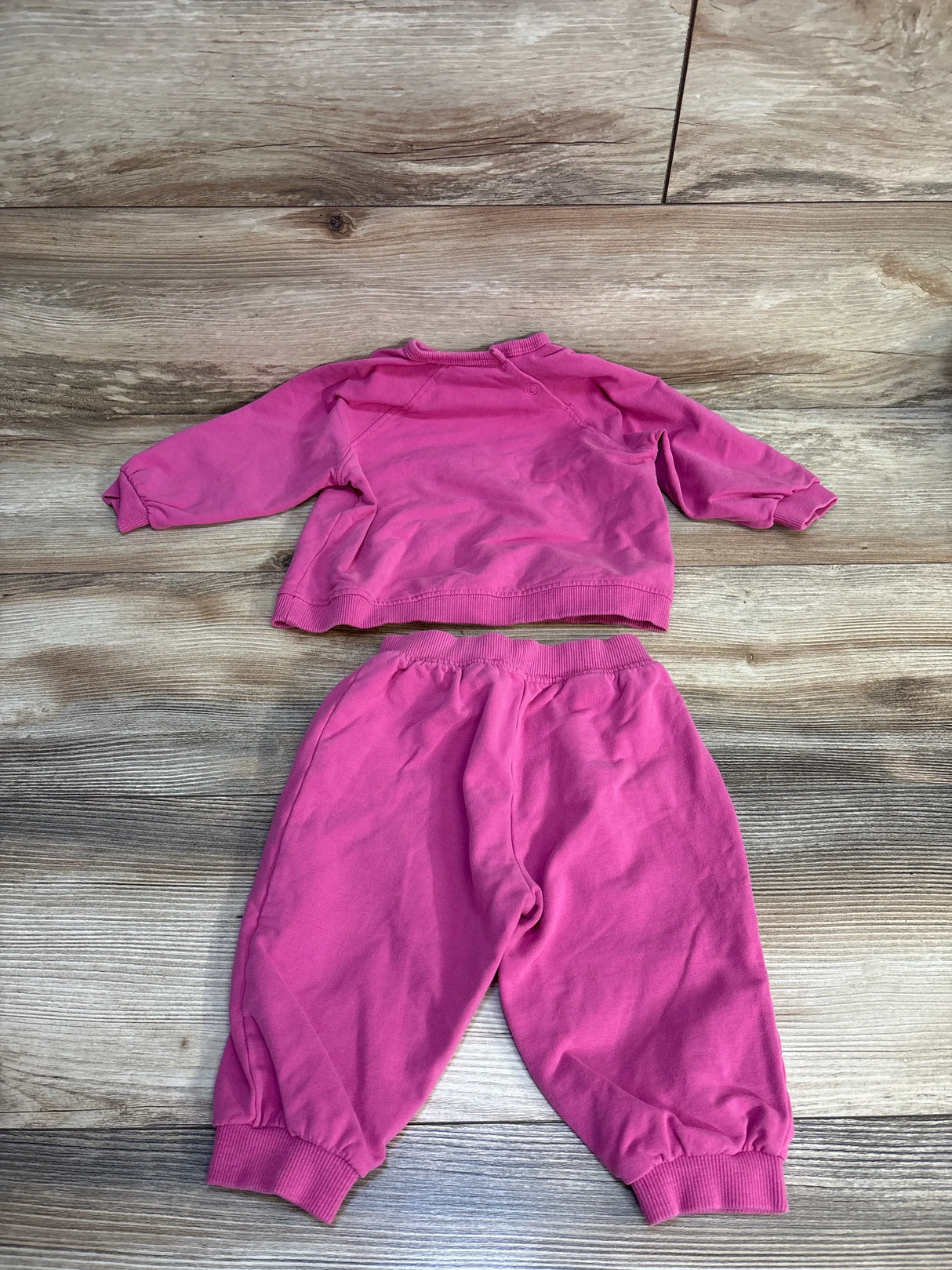 Pink toddler sweatshirt and jogger pants set on wooden floor