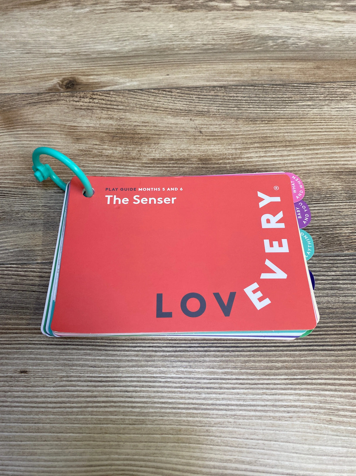 Lovevery play guide booklet titled The Senser for months 5 and 6 on a wooden surface