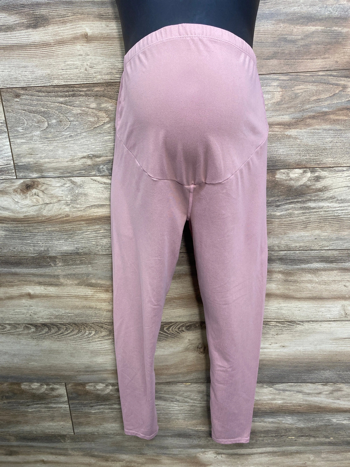 Pink maternity leggings on mannequin, back view, wood floor background