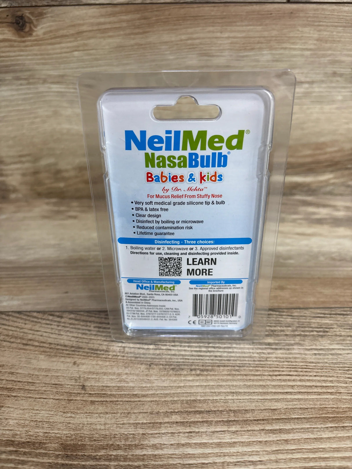 Back view of NeilMed NasaBulb nasal aspirator packaging showing silicone tip, BPA free, on wood surface
