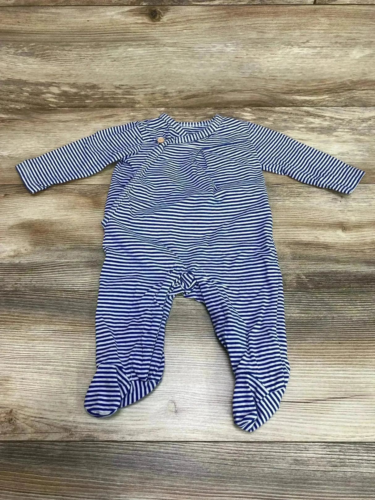 Flat lay of blue and white striped footed coverall size 3-6 months showing long sleeves and built in feet on wood background