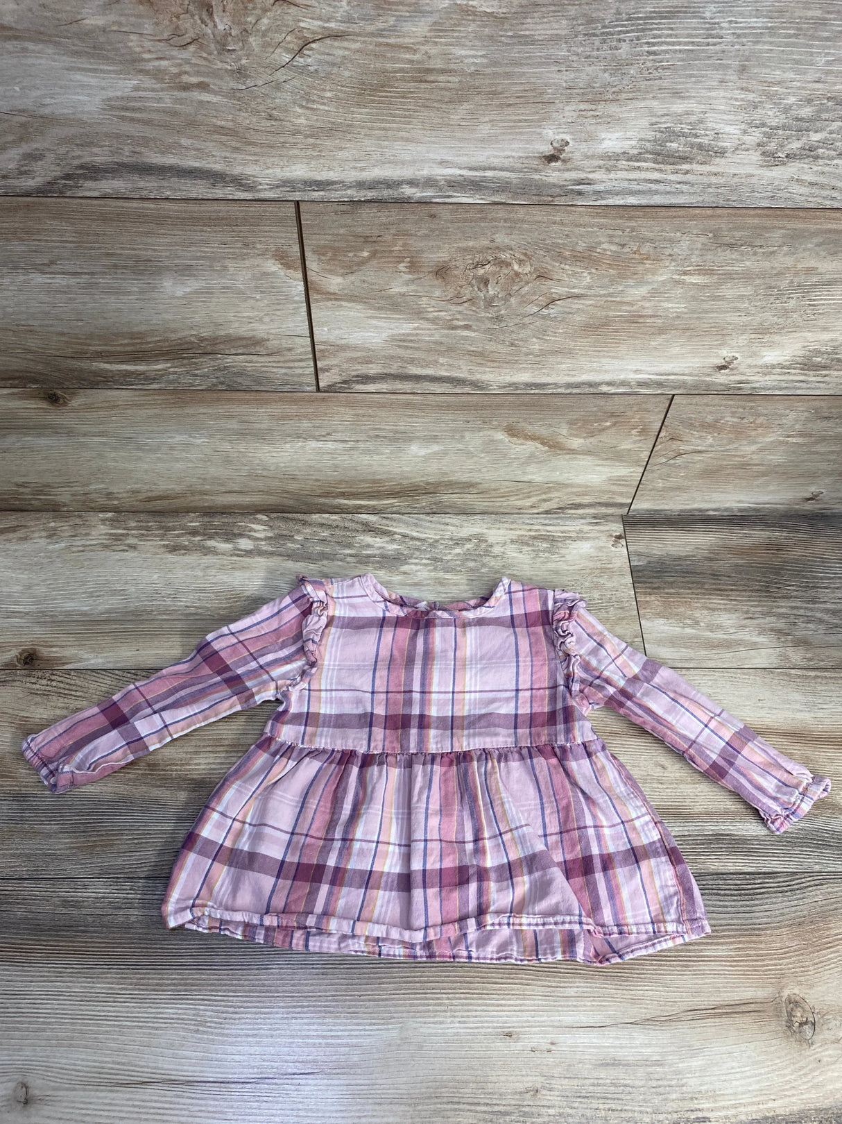 Pink and purple plaid long-sleeve toddler dress with ruffles on wooden floor