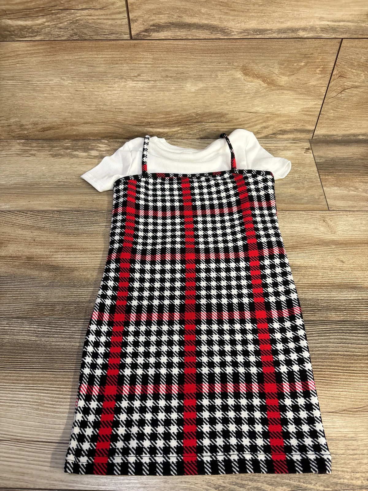 Overhead view of Shein 2pc ribbed shirt and tank dress set showcasing a white shirt and plaid dress on a wood floor