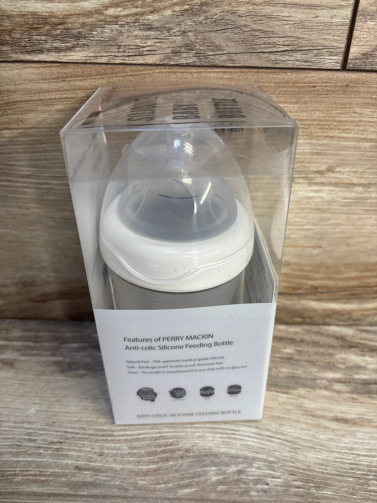 Perry Mackin anti-colic silicone baby feeding bottle in clear packaging on wooden surface