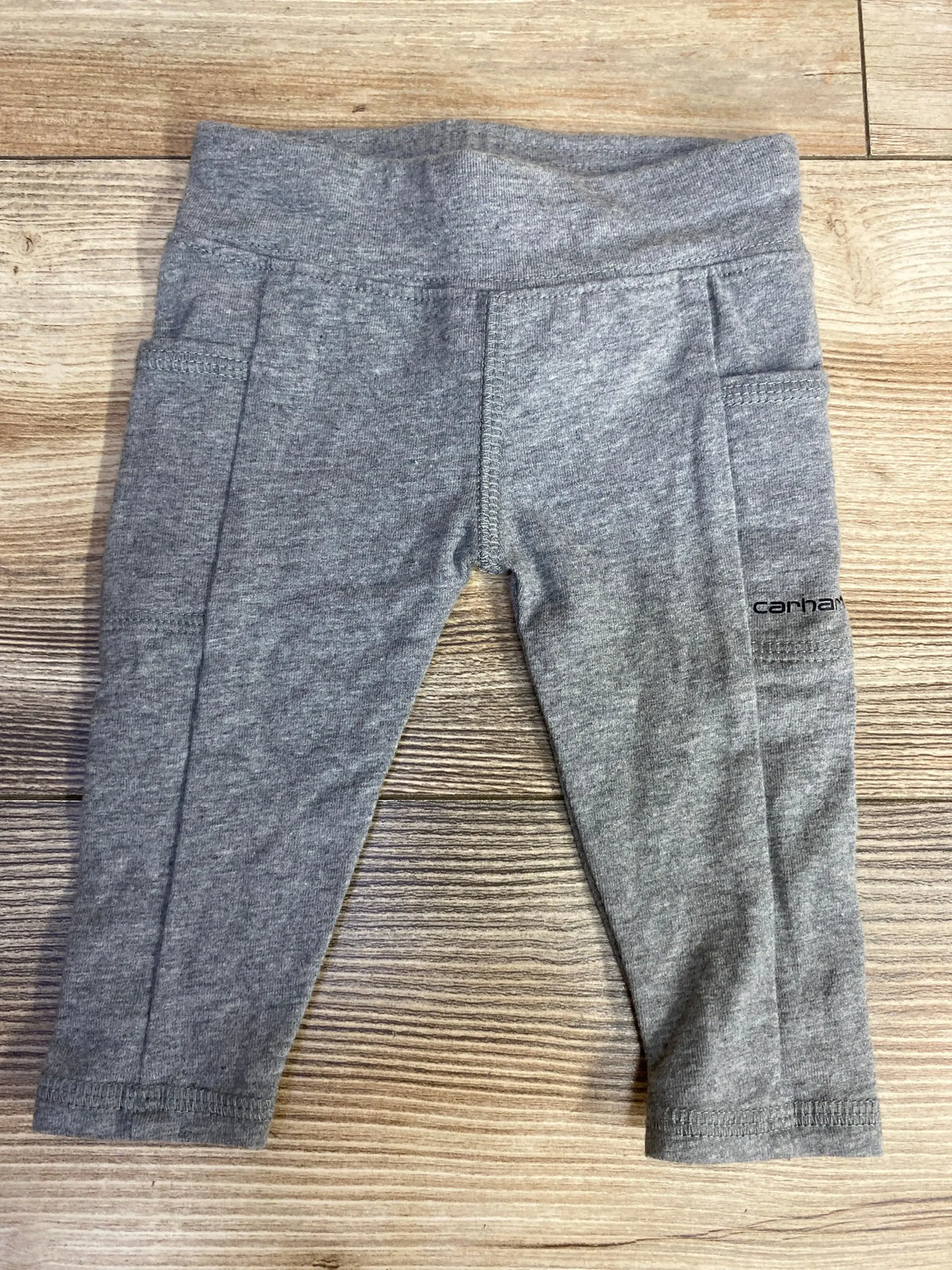 Grey toddler leggings with pockets and Carhartt logo on wooden surface