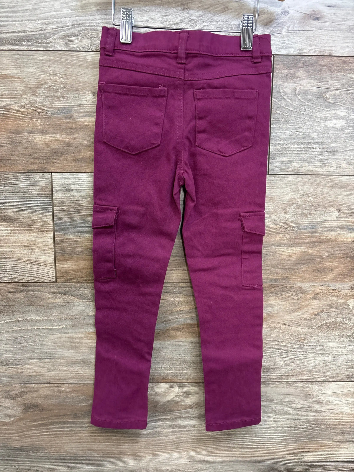 Back view of Dreamstar toddler jeans in purple, size 5T, showing back patch pockets and side cargo pockets on a wood plank background