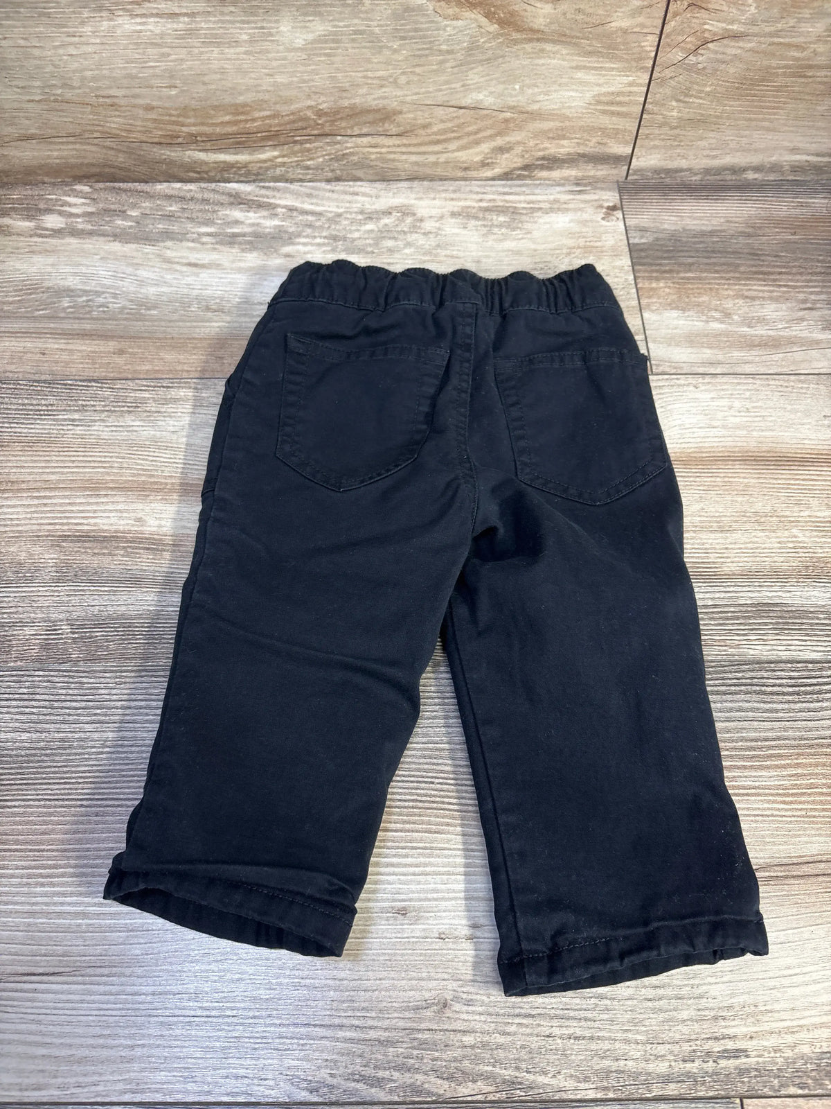Back view of Cat and Jack lined drawstring pants size 12 months showing elastic waistband and back patch pockets on wood floor