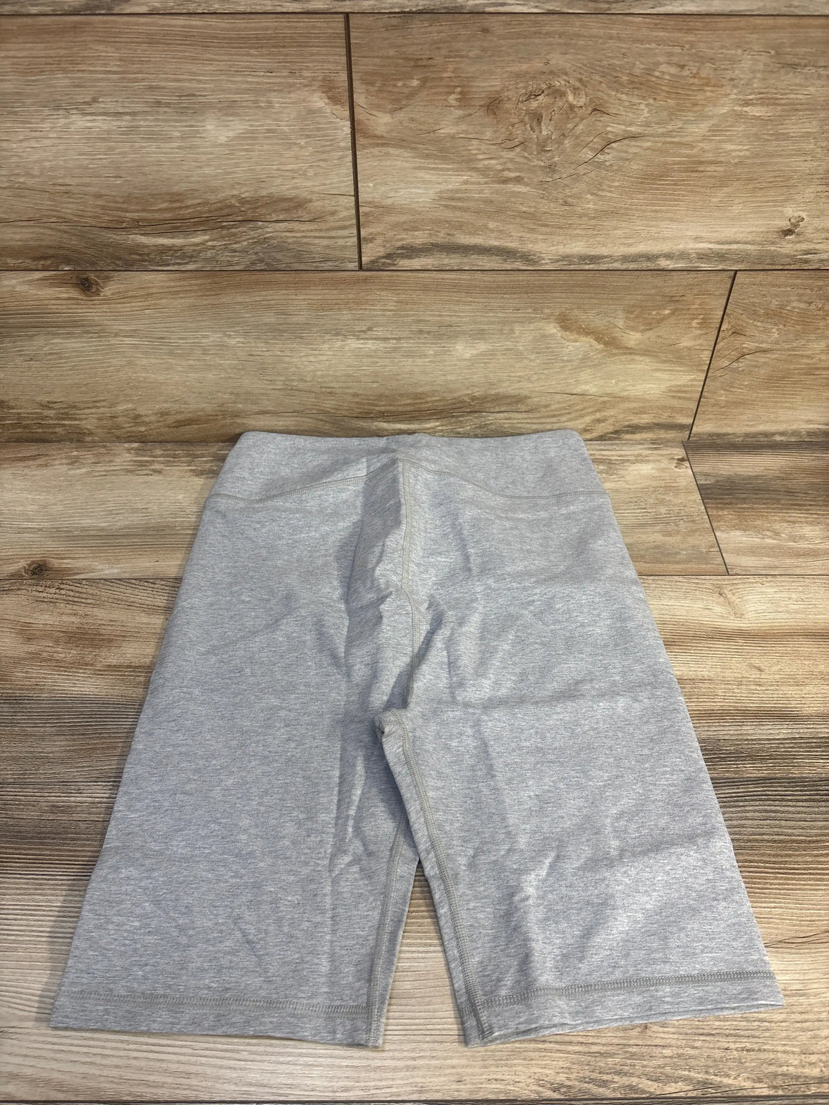 Front view of New Gap maternity bike shorts showcasing the smooth, flat, wide waistband on a wood floor