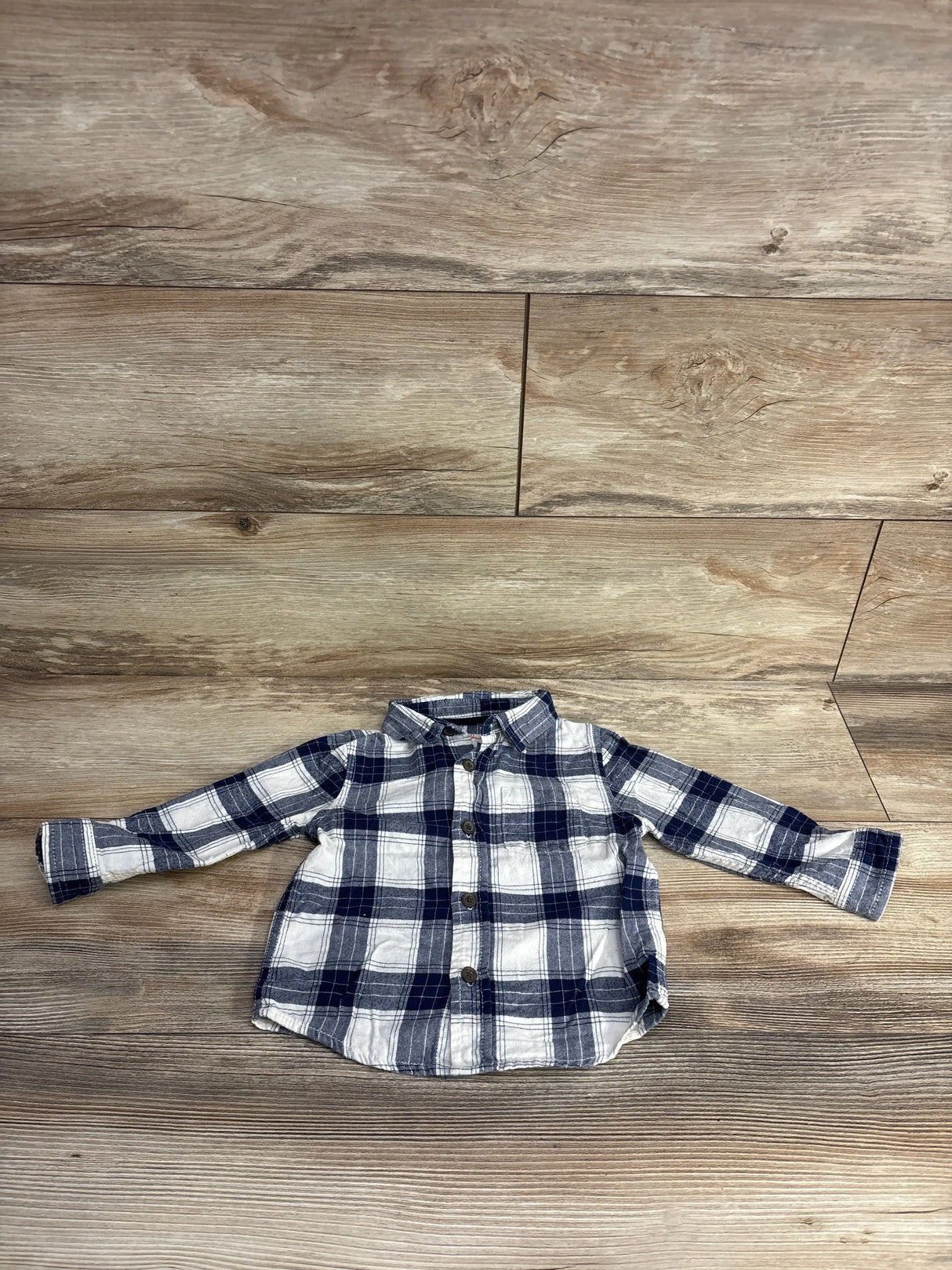 Blue and white plaid long sleeve toddler shirt on wood floor