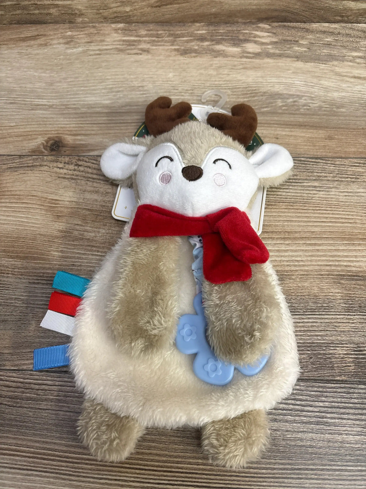 Soft reindeer baby toy with red scarf, teether, and ribbons for sensory play