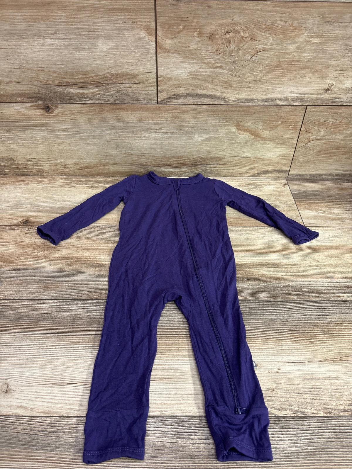 Purple Kyte Baby bamboo footless zippered sleeper for infants, laid flat on a wood background.