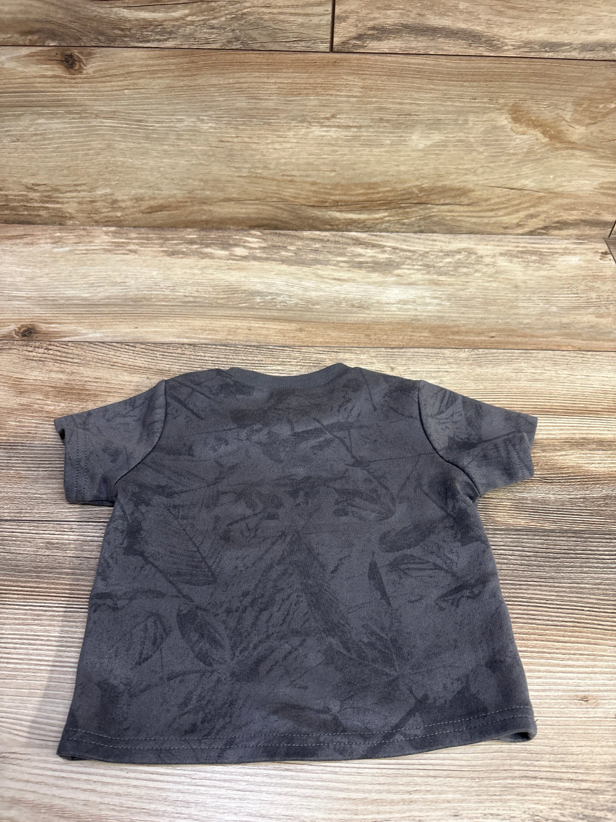 Back view of Shein gray shirt, size 9 to 12 months, with short sleeves and tonal pattern on wood-grain background