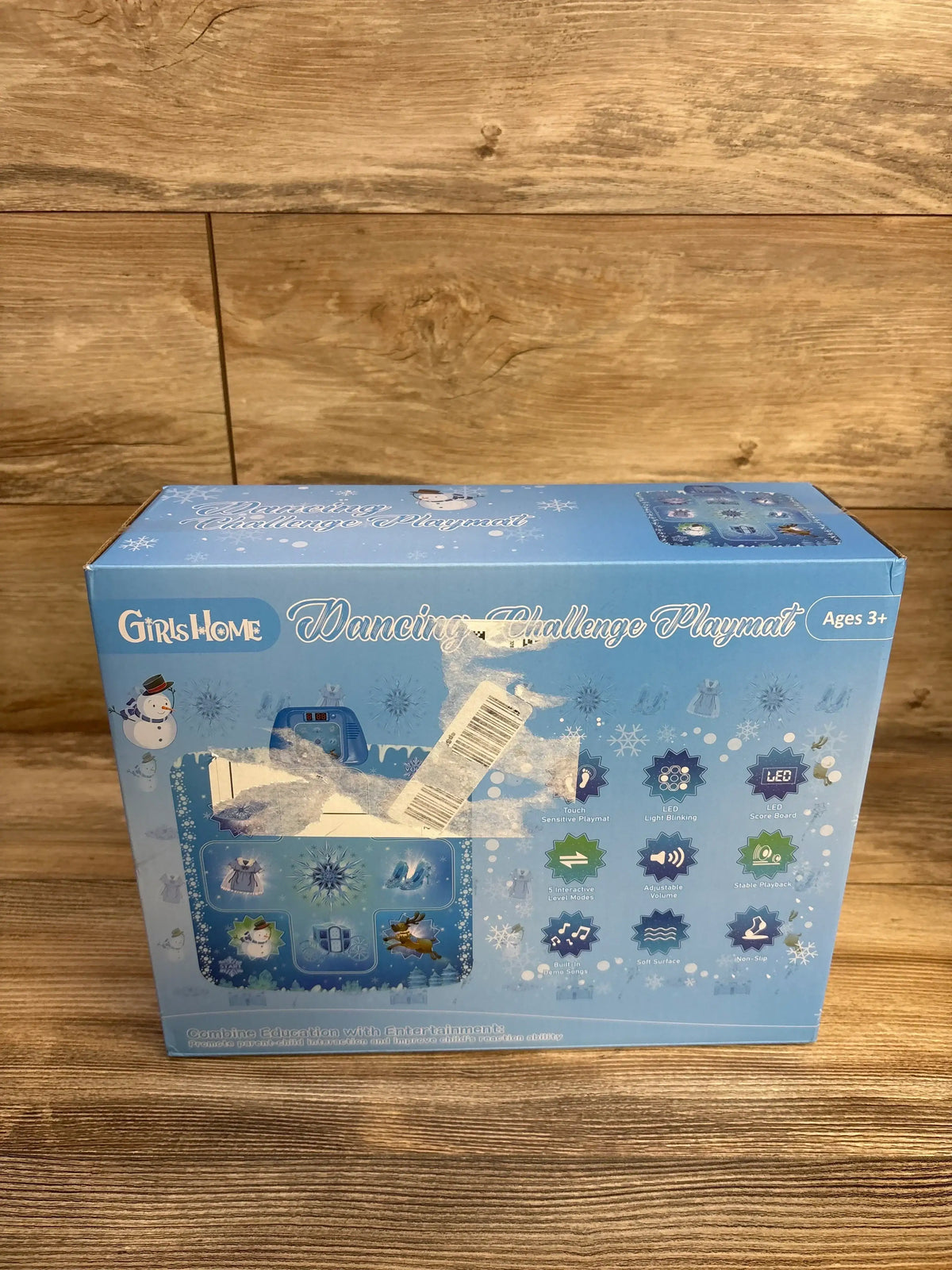 Front view of boxed GirlsHome Frozen electronic dance mat showing blue Frozen artwork and barcode sticker on wooden tabletop