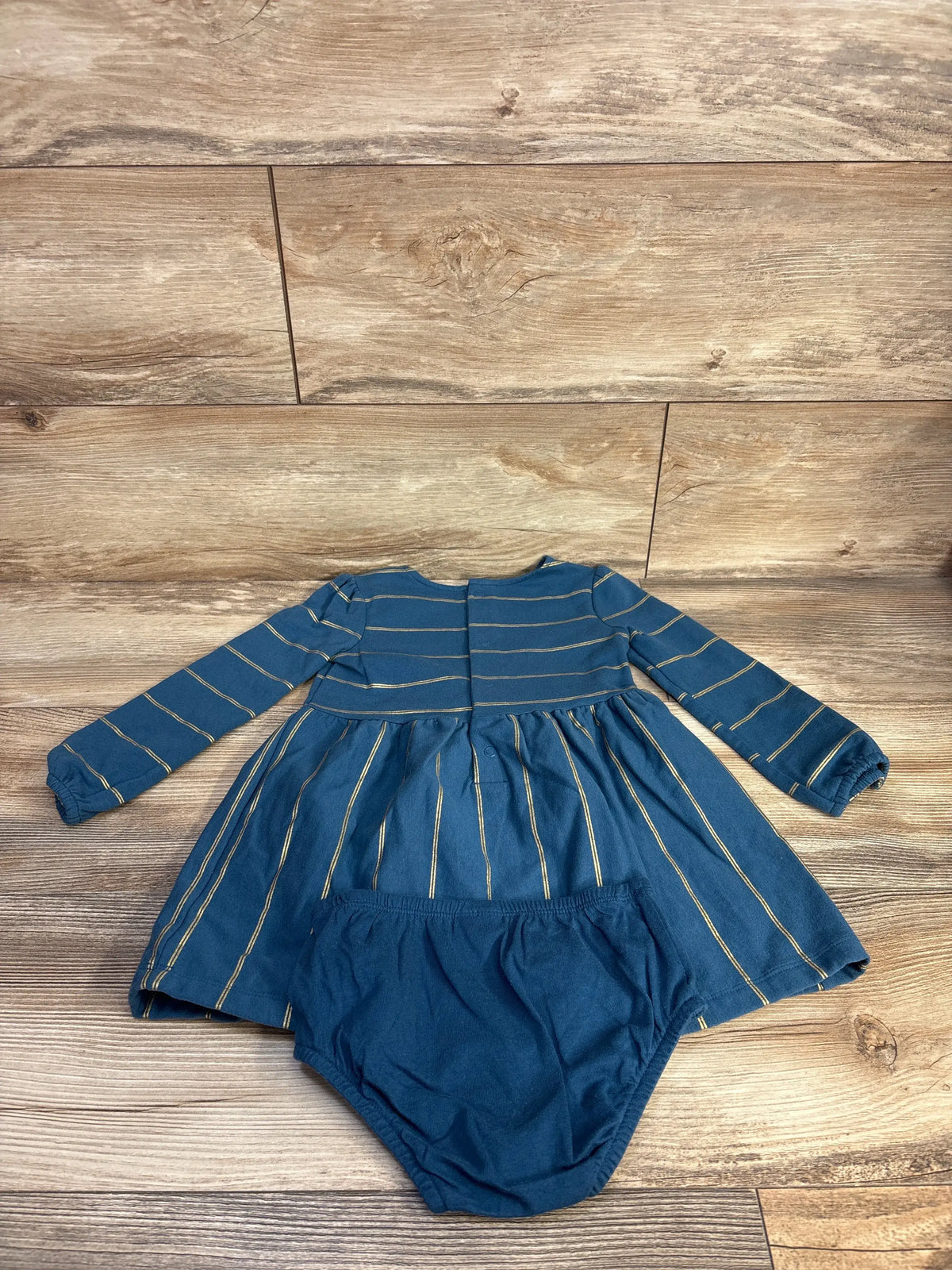 Front view of Carter’s blue striped dress and bloomers set showcasing long sleeves and coordinating bloomers on a wood floor