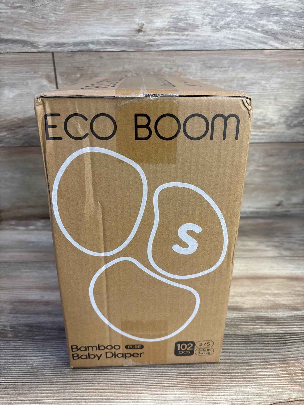 Front view of Eco Boom bamboo baby diaper box showcasing S (Size 2) marking and 102-count label with wooden plank background