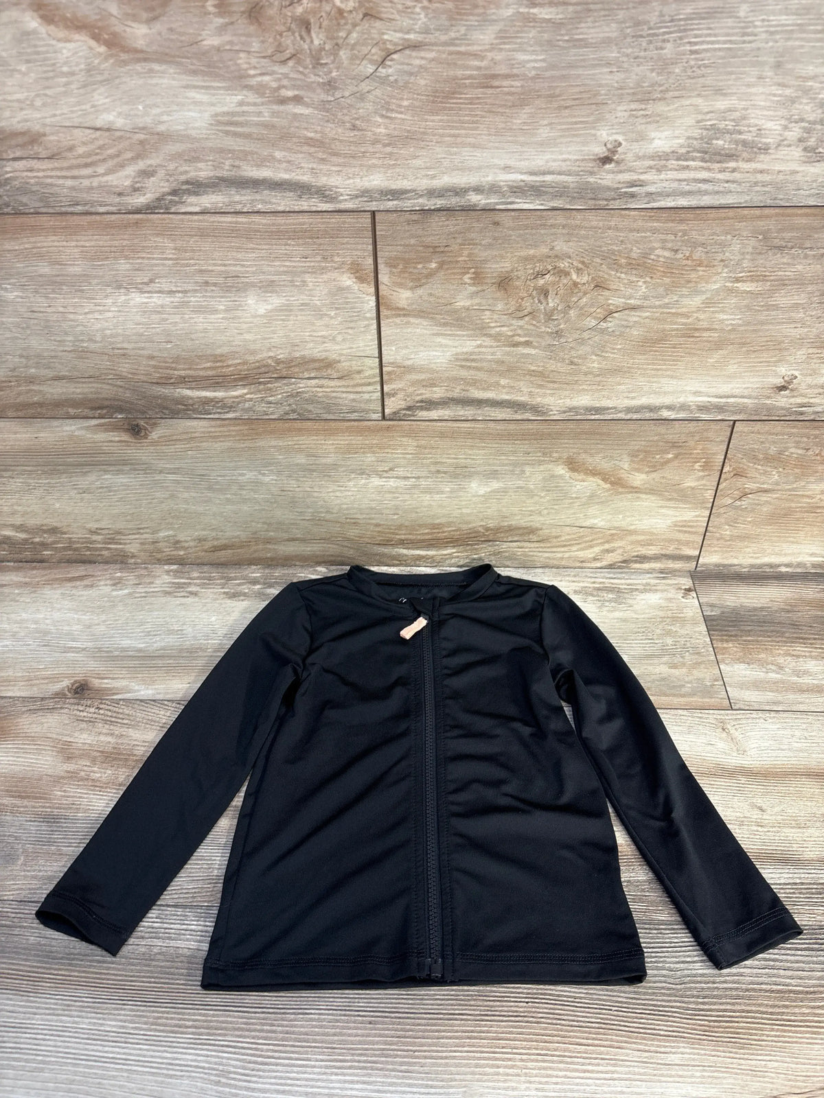 Front view of Cat & Jack full zip rash guard shirt in black showcasing long sleeves and front zipper on a wood-look floor