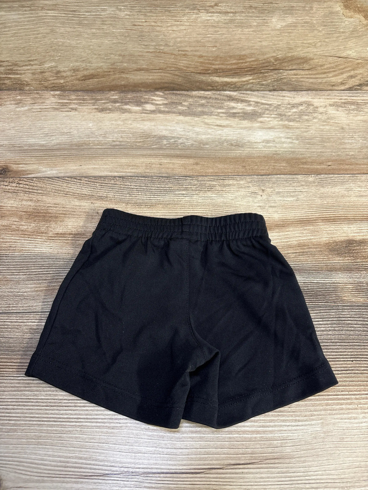Jordan Active black shorts for baby size 12m on a wooden background