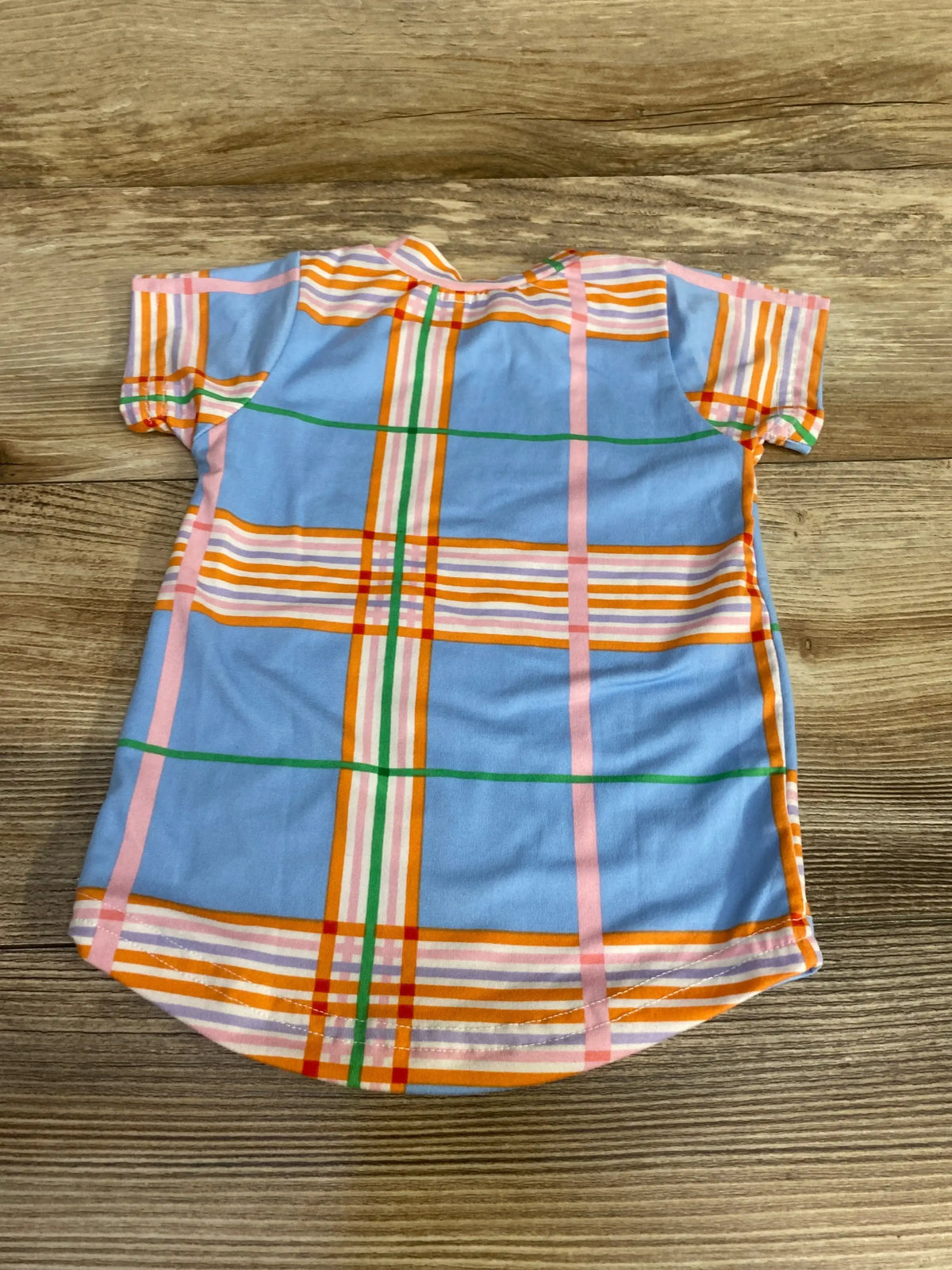 Front view of blue plaid baby shirt in size 12 months showcasing short sleeves and curved hem on a wood background