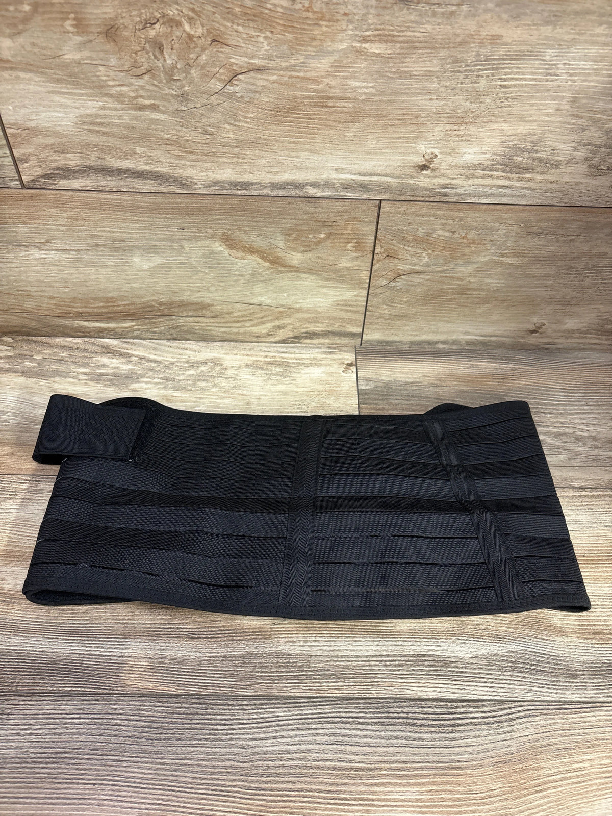 Front view of ChongErfei 3-in-1 pregnancy belly band in black, showing elastic panels and adjustable straps on wood flooring