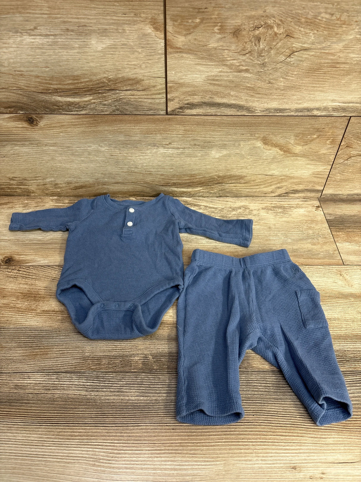Blue waffle knit baby bodysuit and pants set on wood background, long sleeve, gently used
