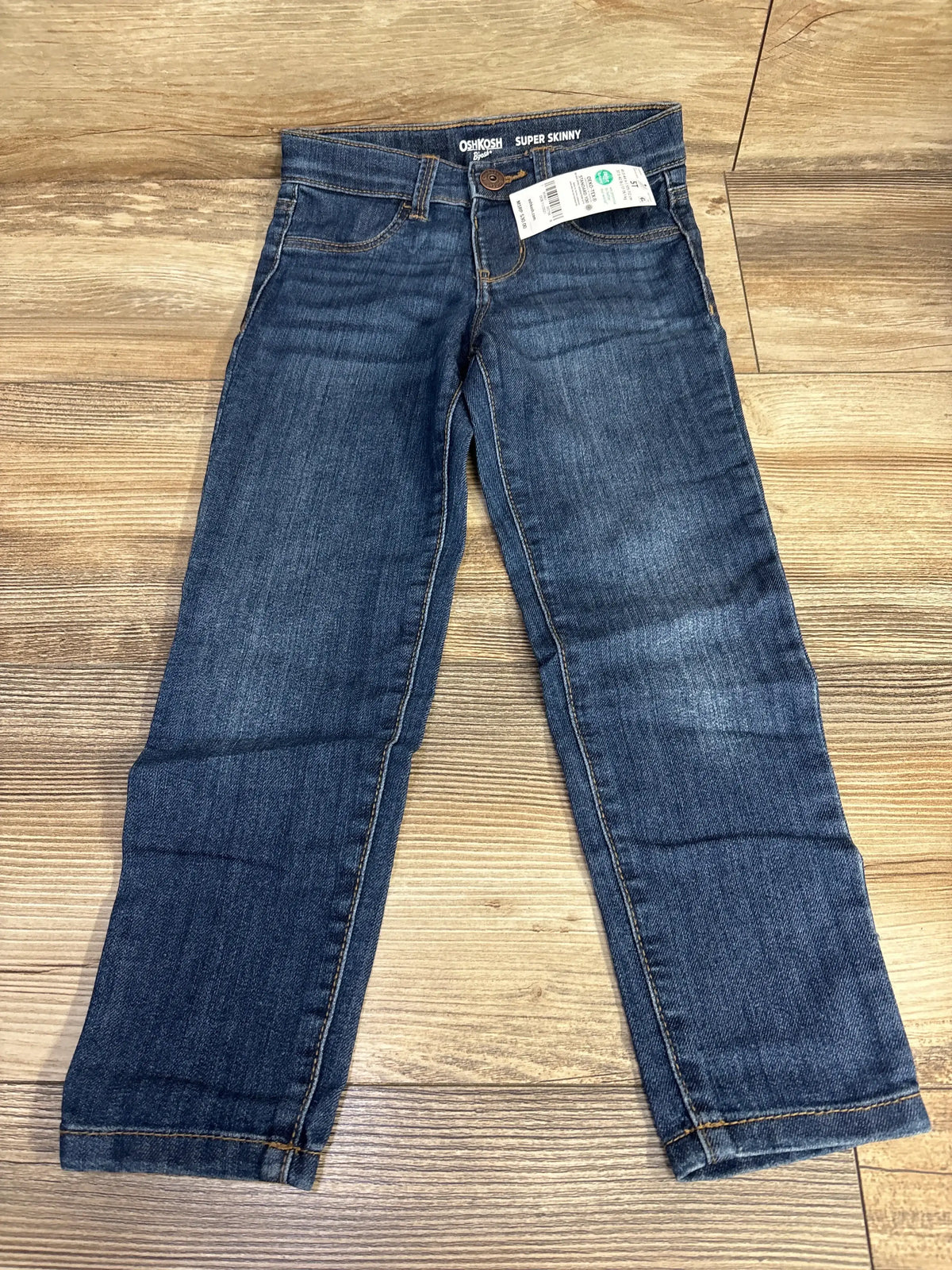 OshKosh children's dark blue super skinny jeans on wood floor, resale kids clothing