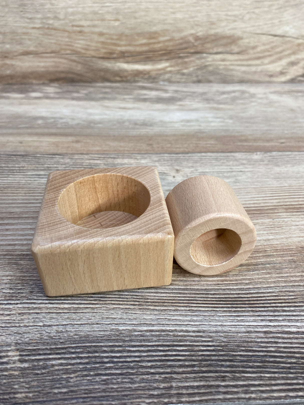 Natural wooden Montessori toy blocks on rustic wood background, cylinder and square shape