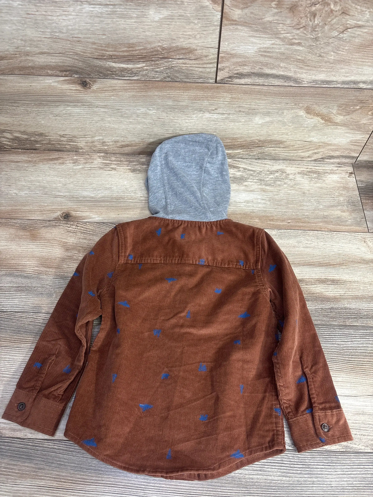 Brown corduroy kids shirt with blue print and gray hood, long sleeves, laid flat