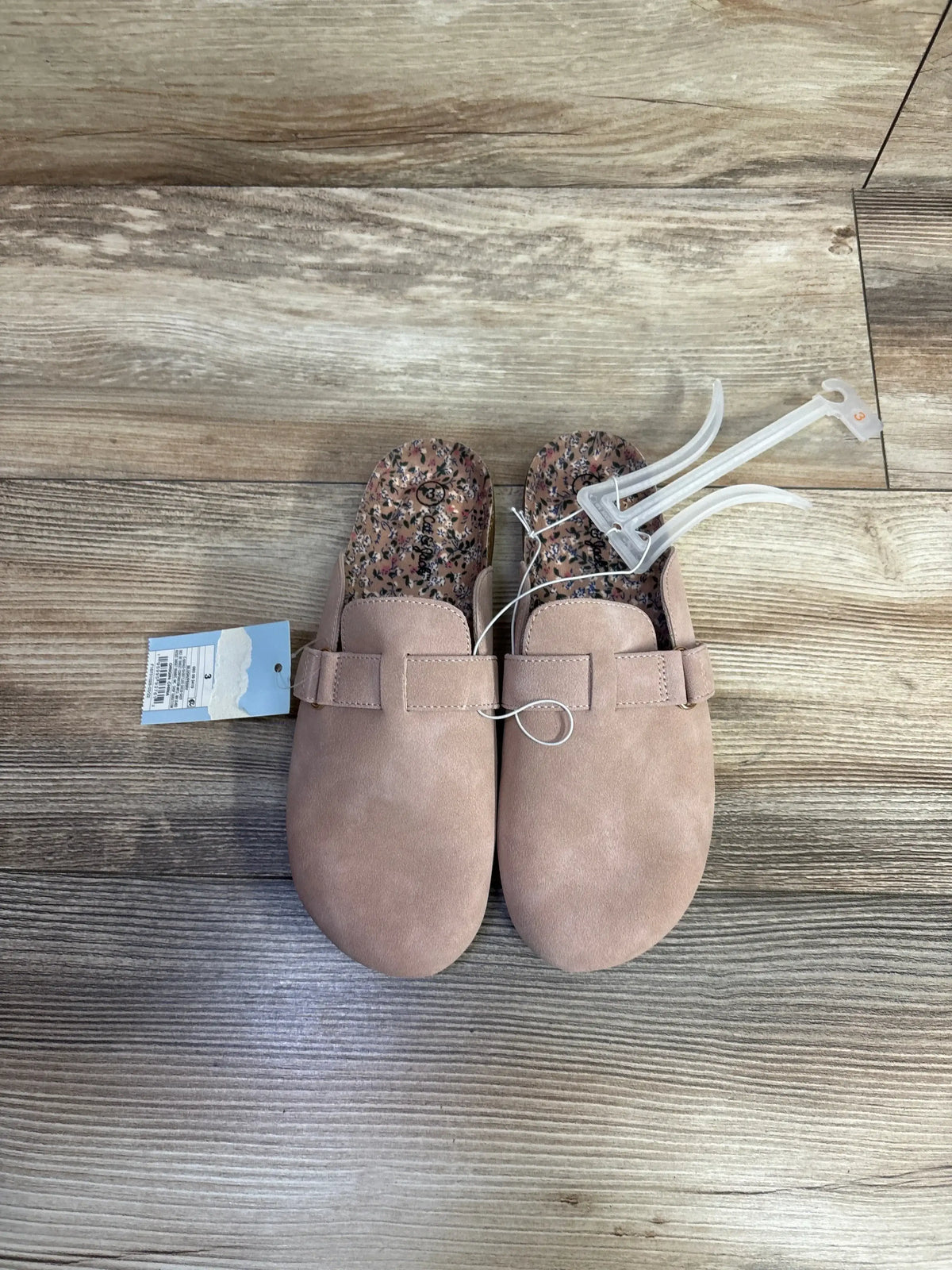 Pair of pink toddler clogs with floral inner soles on wooden floor, children’s resale store item