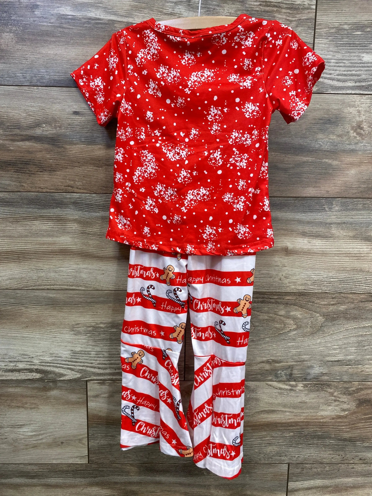 Red and white Christmas-themed kids pajamas with snowflakes and gingerbread patterns