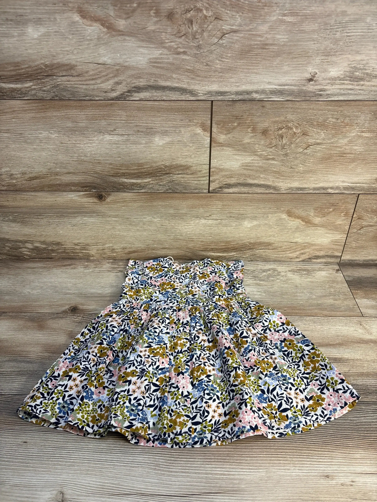 Girls smocked floral dress with blue, pink, and green print on wood background