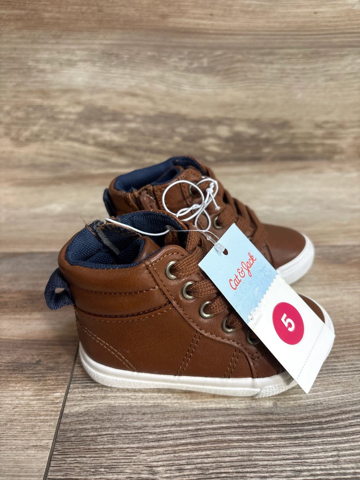 Cat & Jack toddler brown high-top sneakers with size 5 tag on wood background