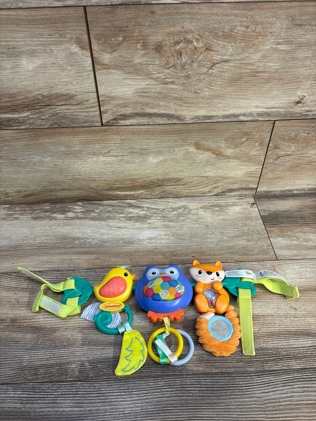 Front view of Infantino Go gaga! Musical Travel Bar Activity Toy with colorful animal toys, rattles, mirror, and straps