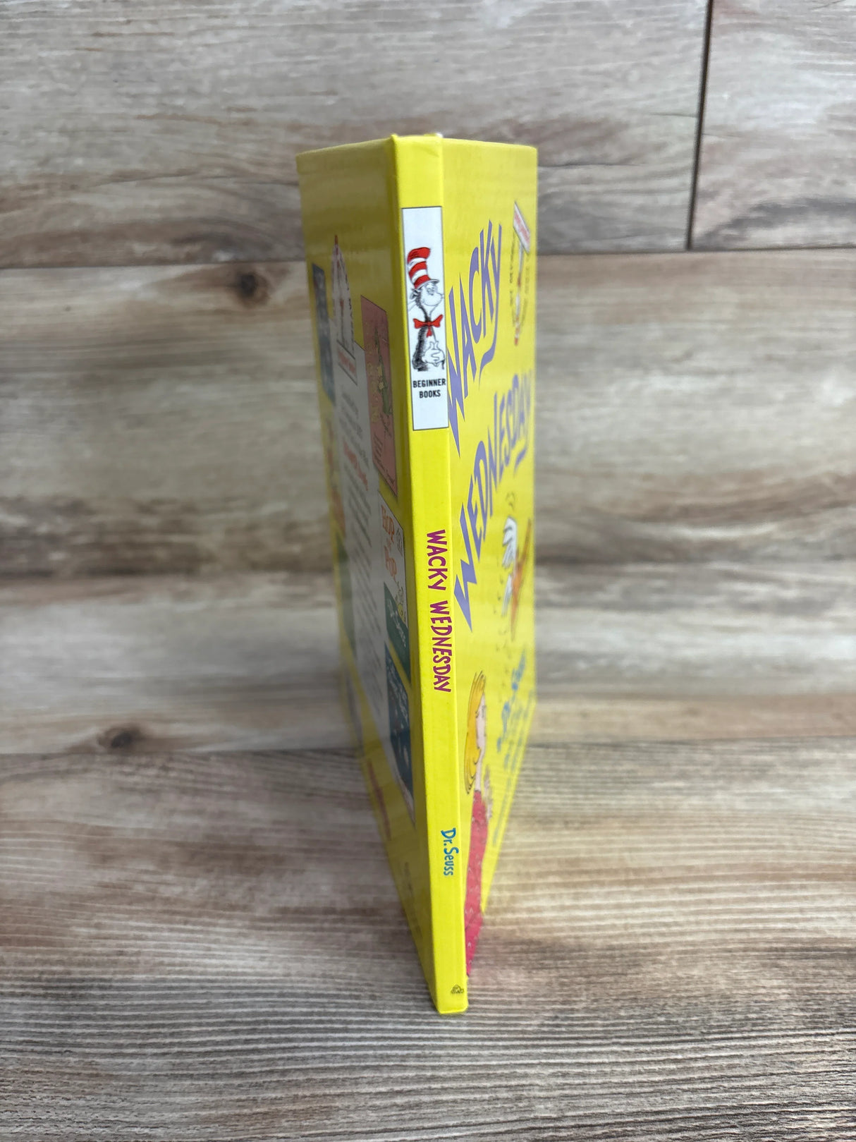 Yellow children's book "Wacky Wednesday" by Dr. Seuss standing upright on wooden surface